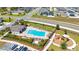 Aerial view of the community pool, playground, lounge chairs, and surrounding greenery at 1471 Mirabella Cir, Davenport, FL 33897