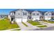 Townhouse exterior showcases gray siding, blue shutters, well-maintained lawns and attached garages at 1471 Mirabella Cir, Davenport, FL 33897