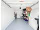 Organized garage space with epoxy flooring and storage shelves, featuring a water heater and side door at 1471 Mirabella Cir, Davenport, FL 33897