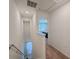 Upstairs hallway featuring carpet flooring, a stairwell, and a bedroom doorway with bright natural light at 1471 Mirabella Cir, Davenport, FL 33897