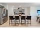 Stylish kitchen featuring gray cabinets, granite countertops, stainless steel appliances, and a large island at 1471 Mirabella Cir, Davenport, FL 33897