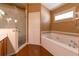 Bright bathroom with tub and shower combination with a view of a glass shower at 14831 Yorkshire Run Dr, Orlando, FL 32828