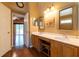 Bathroom vanity featuring double sinks, two mirrors and wood cabinets with views into the bedroom at 14831 Yorkshire Run Dr, Orlando, FL 32828