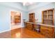Bedroom with built-in shelving, wood flooring, and light blue walls with an adjacent dining area at 14831 Yorkshire Run Dr, Orlando, FL 32828