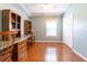 Bedroom with light blue walls, wood floors, built-in shelves, and a large window with blinds at 14831 Yorkshire Run Dr, Orlando, FL 32828