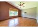 Bedroom with hardwood flooring, a ceiling fan, a large window, and neutral-colored walls at 14831 Yorkshire Run Dr, Orlando, FL 32828