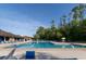 Large community pool featuring a splash fountain, multiple lounge chairs, and umbrellas at 14831 Yorkshire Run Dr, Orlando, FL 32828