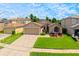 Charming single-story home with a well-manicured lawn, mature landscaping, and a two-car garage at 14831 Yorkshire Run Dr, Orlando, FL 32828