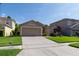Charming single-story home featuring a well-manicured lawn and a two-car garage at 14831 Yorkshire Run Dr, Orlando, FL 32828
