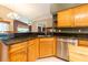 Kitchen featuring granite countertops, oak cabinets, stainless steel appliances, and bar seating at 14831 Yorkshire Run Dr, Orlando, FL 32828