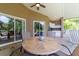Covered lanai with ceiling fan, outdoor kitchen, and table set, perfect for entertaining or enjoying meals outdoors at 14831 Yorkshire Run Dr, Orlando, FL 32828