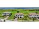 Aerial view of community homes with lush greenery and a water view in the distance at 1551 Gateway Ln, Kissimmee, FL 34746