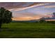 Open green field with a distant view of a lake, clouds and stunning sunset colors at 1551 Gateway Ln, Kissimmee, FL 34746