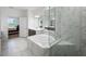 An elegant bathroom featuring a modern tub, a glass shower, and beautiful tile work at 1551 Gateway Ln, Kissimmee, FL 34746