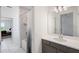 Stylish bathroom with a marble-tiled shower, gray vanity, and well-lit mirror at 1551 Gateway Ln, Kissimmee, FL 34746