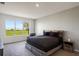 Bedroom boasts a scenic outdoor view, neutral paint, and is accented by a rustic modern bed and side table at 1551 Gateway Ln, Kissimmee, FL 34746
