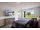 Bedroom with large windows, allowing natural light and scenic views, features a modern dresser and mounted tv at 1551 Gateway Ln, Kissimmee, FL 34746