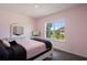 Cozy bedroom with a soft pink color scheme, complemented by a window view and comfortable furnishings at 1551 Gateway Ln, Kissimmee, FL 34746