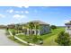 A side view of a two-story home featuring lush green grass and mature palm trees at 1551 Gateway Ln, Kissimmee, FL 34746
