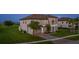 Elegant two-story home featuring a well-manicured lawn and a welcoming front entrance with palm trees at 1551 Gateway Ln, Kissimmee, FL 34746