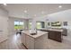 Open kitchen with an island, breakfast bar, stainless steel appliances, and views of the backyard and living room at 1551 Gateway Ln, Kissimmee, FL 34746