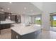 Modern kitchen featuring gray cabinetry, quartz countertops, stainless steel appliances, and an island with bar seating at 1551 Gateway Ln, Kissimmee, FL 34746