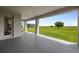 Covered patio with a serene view of a green field and open sky, perfect for outdoor relaxation at 1551 Gateway Ln, Kissimmee, FL 34746