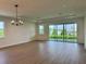 Spacious living room with a chandelier, neutral walls, and sliding glass doors to the backyard at 1646 Pinecliff Dr, Apopka, FL 32703