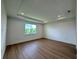 Main bedroom with a tray ceiling, wood floors, and a window at 1646 Pinecliff Dr, Apopka, FL 32703