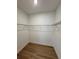 Empty walk-in closet featuring wood flooring and metal shelving at 1646 Pinecliff Dr, Apopka, FL 32703
