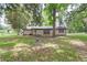 Exterior showing a well-maintained backyard with a stone fire pit, and mature trees creating a perfect space for relaxation at 1753 Nw 44Th St, Ocala, FL 34475