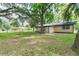 Exterior of home shows a sprawling backyard with mature trees and a stone fire pit, ideal for outdoor enjoyment and entertaining at 1753 Nw 44Th St, Ocala, FL 34475