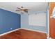 Blue-painted bedroom featuring a ceiling fan, window, and hardwood floors at 1753 Nw 44Th St, Ocala, FL 34475