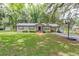 Inviting single-story home with a well-maintained lawn, mature trees providing ample shade, and a cozy front porch at 1753 Nw 44Th St, Ocala, FL 34475