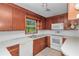 Kitchen features wooden cabinets, white appliances and ample natural light from the window at 1753 Nw 44Th St, Ocala, FL 34475