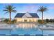 Resort-style pool area with lounge chairs, palm trees, and a community clubhouse at 1880 Stonecliff Dr, Apopka, FL 32703