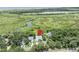 Aerial view of a house close to the water, surrounded by trees, with a pin marking the property location at 195 River Village Drive, Debary, FL 32713