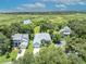 Stunning aerial shot of a blue single-Gathering home surrounded by nature and trees and boasting an exceptionally picturesque view at 195 River Village Drive, Debary, FL 32713