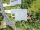 Aerial view of a well-maintained home with a landscaped yard, gray roof, and a charming patio area surrounded by lush greenery at 195 River Village Drive, Debary, FL 32713