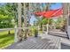 Inviting wooden deck with a vibrant red awning and serene views of lush greenery at 195 River Village Drive, Debary, FL 32713