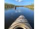 Enjoy a tranquil kayaking experience on the calm waters surrounded by lush greenery and clear blue skies at 195 River Village Drive, Debary, FL 32713