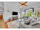 Comfortable living room featuring a ceiling fan, large windows, and a cozy seating area at 195 River Village Drive, Debary, FL 32713