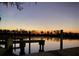 Scenic lakeside view featuring a wooden pier at dusk, reflecting the calm water and the soft colors of the evening sky at 195 River Village Drive, Debary, FL 32713