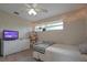 Cozy bedroom with wood-look floors, featuring a TV, white dresser, and window with lights at 200 Hummingbird Ln, Longwood, FL 32779