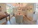 Inviting dining room with tray ceilings, a modern light fixture, and views of the backyard from its bright windows at 200 Hummingbird Ln, Longwood, FL 32779