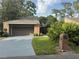 Charming brick home with a well-manicured front yard, mature trees, and a two-car garage at 200 Hummingbird Ln, Longwood, FL 32779