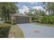View of the two-car garage with neutral paint, driveway, and manicured landscaping in the surrounding yard at 200 Hummingbird Ln, Longwood, FL 32779