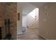 Inviting hallway featuring light-colored wood-look flooring and a staircase with white railing and brick fireplace at 200 Hummingbird Ln, Longwood, FL 32779