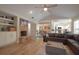 Cozy living room featuring a brick fireplace, built-in shelves, and an open layout with views to the dining and kitchen at 200 Hummingbird Ln, Longwood, FL 32779