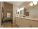 Bright main bathroom with dual sinks and a vanity, featuring an attached bedroom and wood-look floors at 200 Hummingbird Ln, Longwood, FL 32779